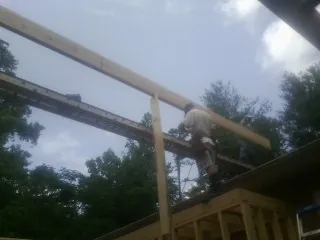 Carpenter setting a ridge beam over a new addition frame — Ice Dam Removal by Roofing Brothers in Hagarville