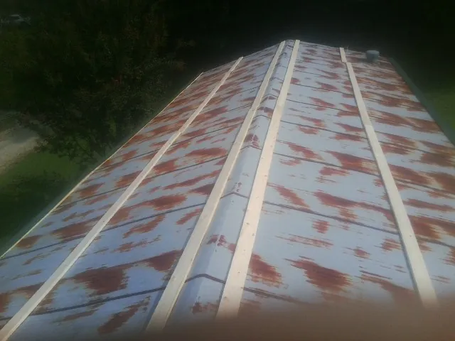Rusted metal roof panels with new wood purlins before replacement — Storm Damage Roof Repair in Hagarville by Roofing Brothers