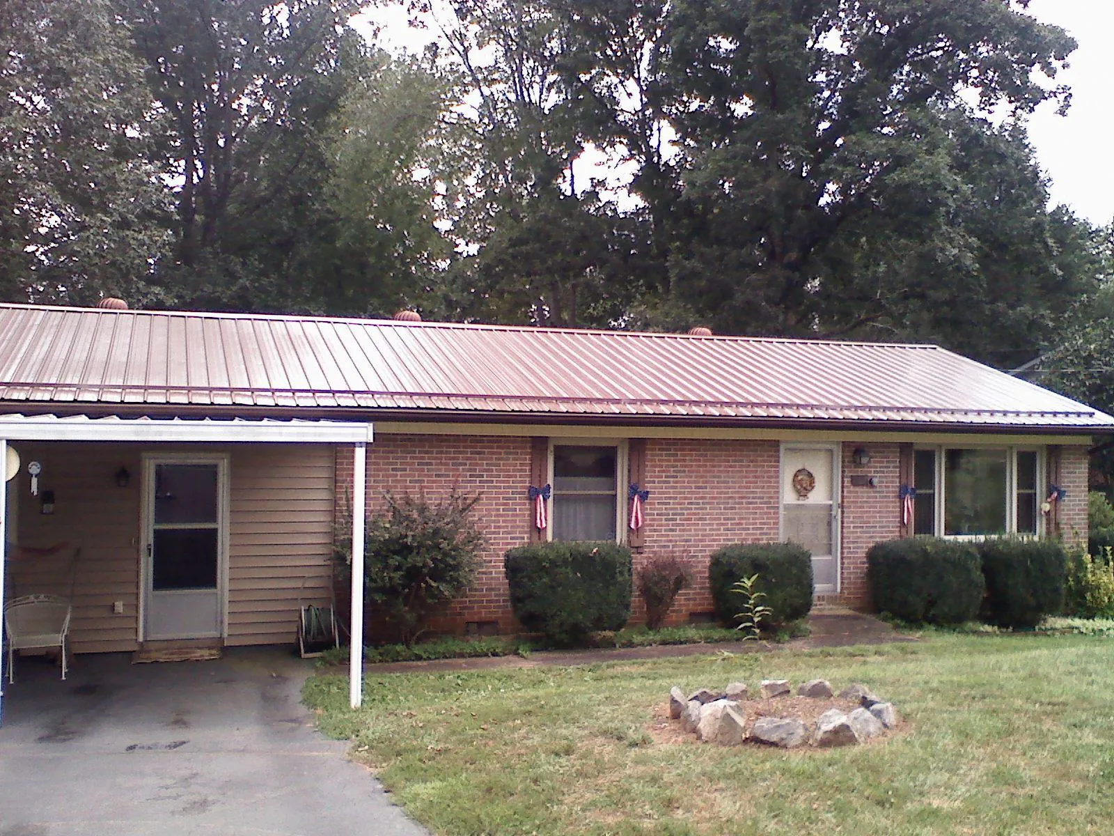 Bronze metal roof and carport on a brick ranch home — Roof Repair work by our crew in Hagarville